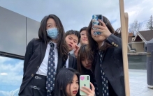 李嫣分享学校宿舍内景：书桌放着卷筒纸和画笔，墙上张贴着课表